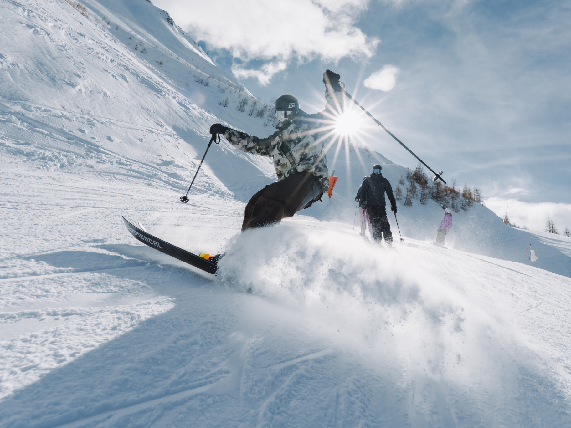2 skieurs sur une piste avec des mélèzes et de la montagne enneigé en arrière plan 
